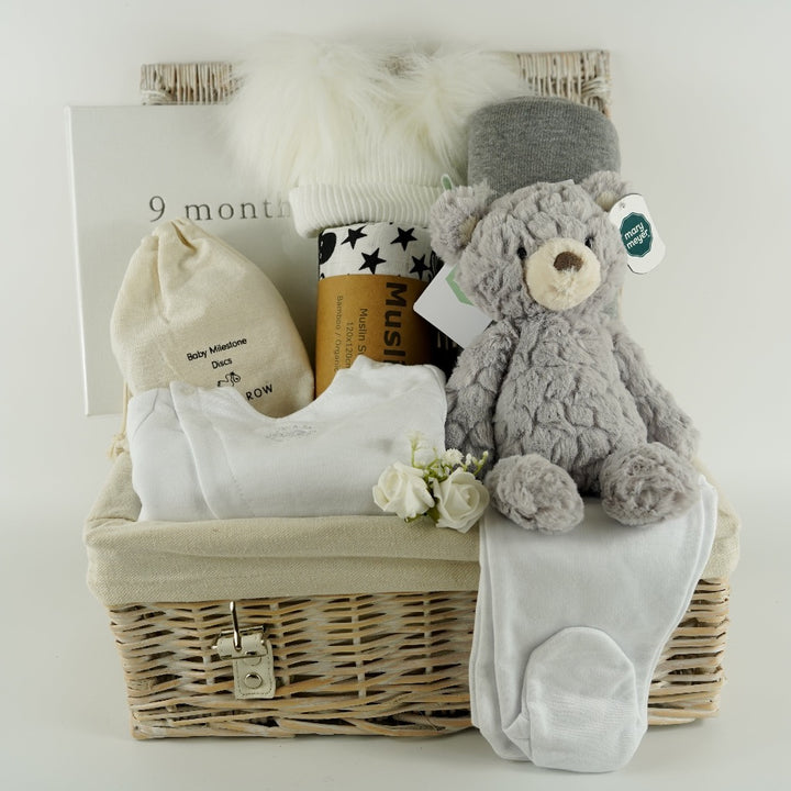 Pregnancy hamper basket with grey teddy, grey baby blanket with stars , black and white sensory baby swaddle, white baby hat with 2 Pom poms . White pregnancy journal. Pregnancy milestone discs, white baby clothing set includes jacket, bodysuit and leggings