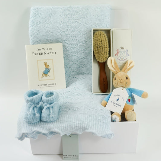 baby boy hamper, blue shawl by G H Hurts, blue knit booties , peter rabbit book, baby natural hairbrush, peter rabbit  soft toy rattle