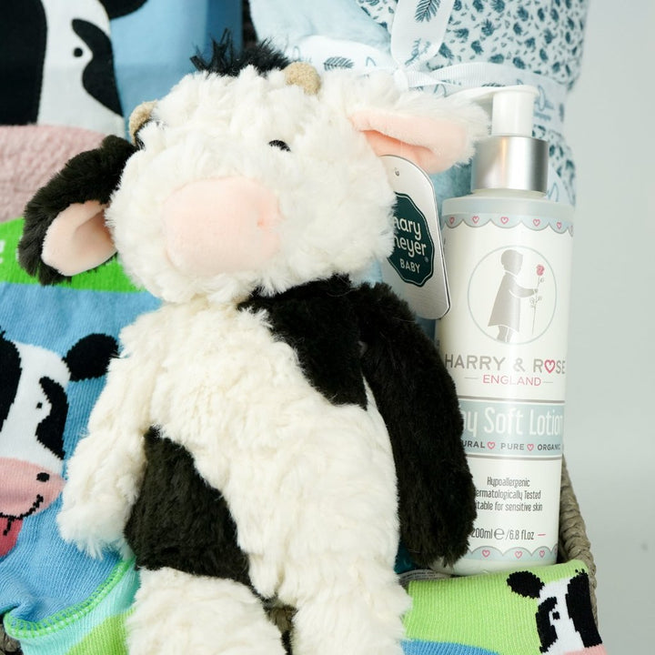 baby boy hamper, blue baby clothing set with long sleeved blue tshirt and leggings with cow on the bottom, baby toiletries, soft doudou baby blanket, baby socks