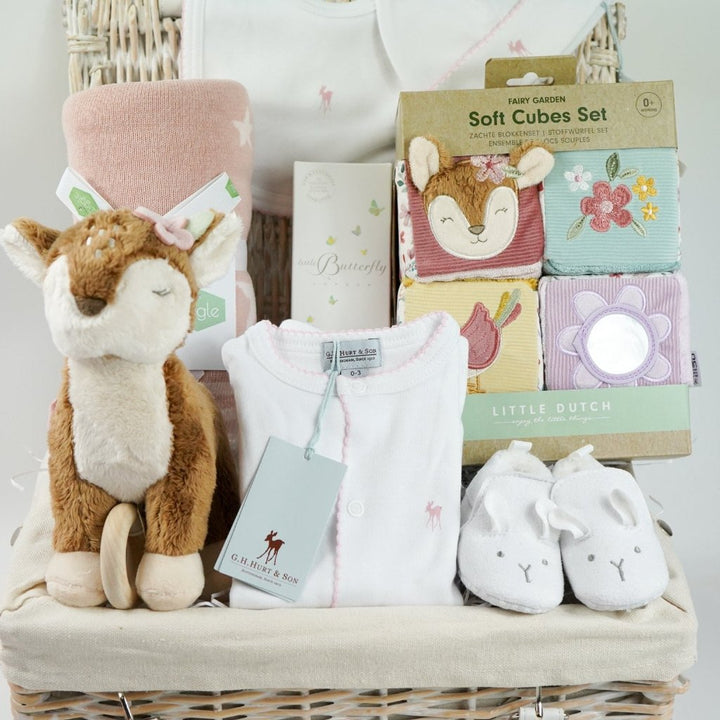 luxury baby hamper with sof cuddly deer with music, luxury white clothing set with pink deer and pink picot edging on sleepsuit, hat and baby bib, soft pink blanket with pale pink stars, white baby slippers with ears, set of four soft blocks with fawn and flowers