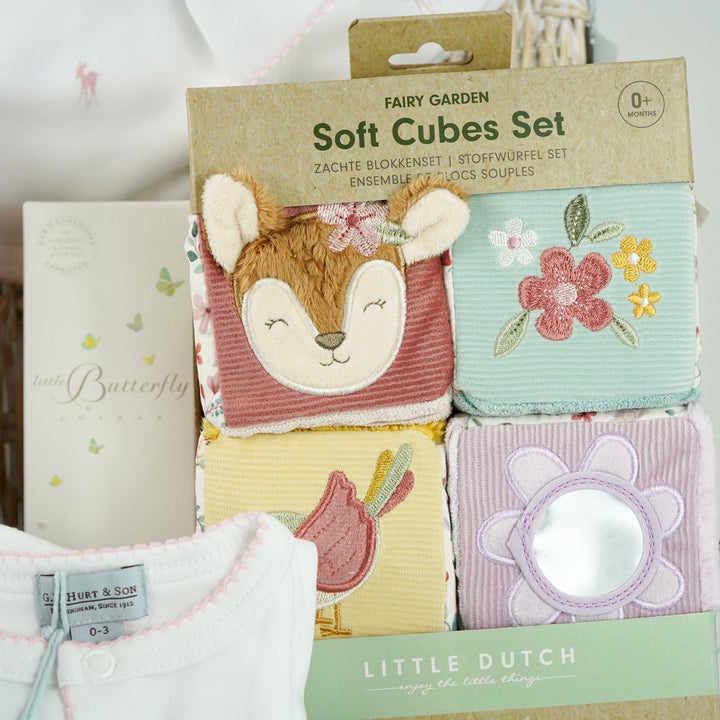 luxury baby hamper with sof cuddly deer with music, luxury white clothing set with pink deer and pink picot edging on sleepsuit, hat and baby bib, soft pink blanket with pale pink stars, white baby slippers with ears, set of four soft blocks with fawn and flowers