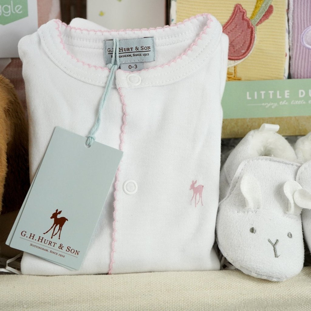 luxury baby hamper with sof cuddly deer with music, luxury white clothing set with pink deer and pink picot edging on sleepsuit, hat and baby bib, soft pink blanket with pale pink stars, white baby slippers with ears, set of four soft blocks with fawn and flowers