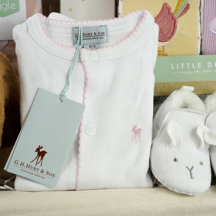 luxury baby hamper with sof cuddly deer with music, luxury white clothing set with pink deer and pink picot edging on sleepsuit, hat and baby bib, soft pink blanket with pale pink stars, white baby slippers with ears, set of four soft blocks with fawn and flowers