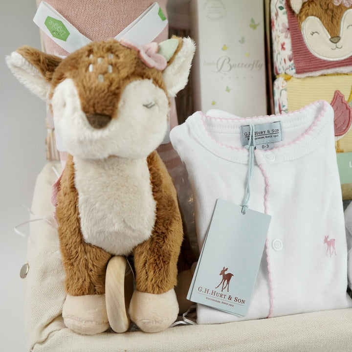 luxury baby hamper with sof cuddly deer with music, luxury white clothing set with pink deer and pink picot edging on sleepsuit, hat and baby bib, soft pink blanket with pale pink stars, white baby slippers with ears, set of four soft blocks with fawn and flowers