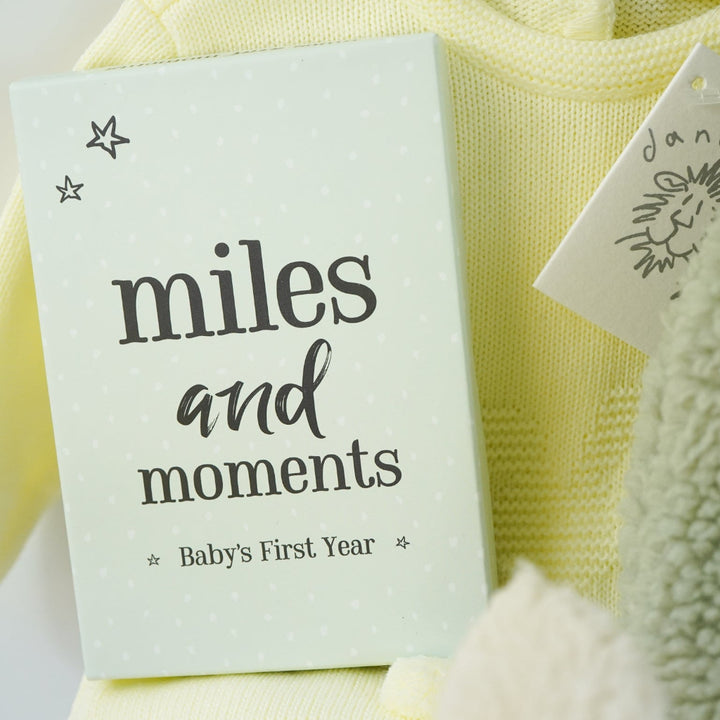 easter baby hamper, yellow knit romper with bunny design and pompom tail, soft fluffy bunny ears green hat with matching bunny ears , booties , recycled cream bunny cuddle toy, miles and moments baby cards, hot chocolate spoon with small eggs