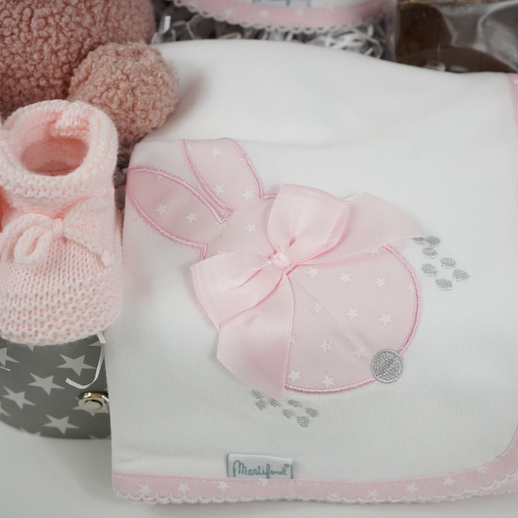 baby keepsake trunk with pink Miffy teddy, white bib with pink scalloped edge and applique bunny design , matching white wrap with pink edging and bunny applique design, pink booties , chocolate sppon with easter eggs