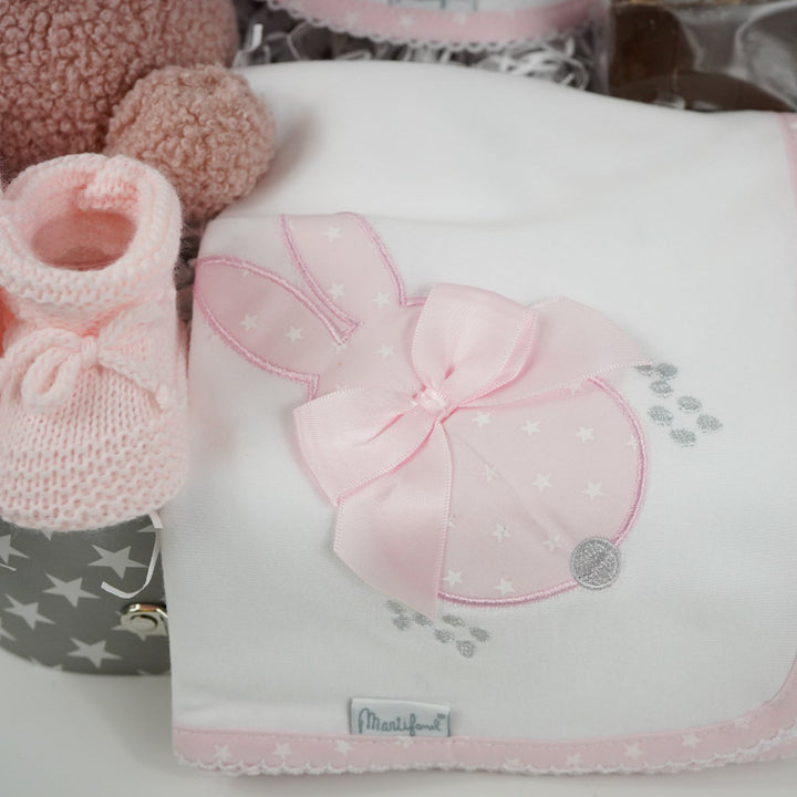 baby keepsake trunk with pink Miffy teddy, white bib with pink scalloped edge and applique bunny design , matching white wrap with pink edging and bunny applique design, pink booties , chocolate sppon with easter eggs