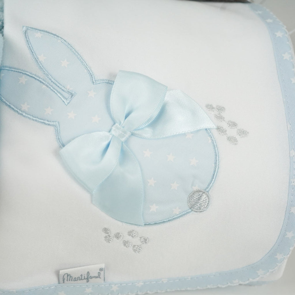 baby case with Blue miffy bunny, white and pale blue baby bib with applique bunny with a ribbon, white wrap with blue applique bunny with ribbon bow, blue knit booties