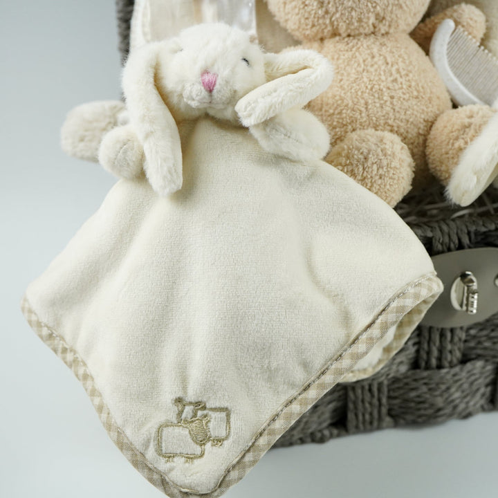 neutral baby gift hamper with  beige and caramel heart blanket with pompoms, baby dressing gown with cute ears, baby bunny slipper and matching bunny comforter, caramel miffy soft toy, chocolate spoon