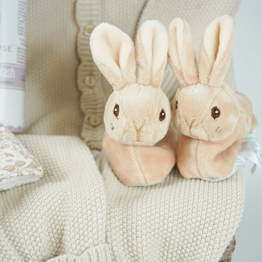 luxury baby girl hamper basket with taupe knitted romper with scalloped edges, cream cellular bamboo and cotton blanket, taupe and dusty pink flopsy bunny comforter , perter rabbit plush slippers , organic baby bubble bath