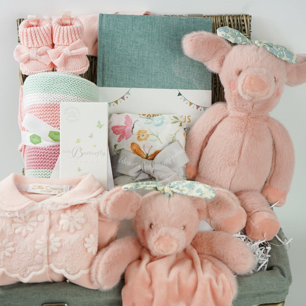 baby girl  hamper basket, pink pig baby comforter with chintz headband, pink pig soft toy with chintz headband, baby journal, organic baby toiletries, pink baby  bookies with a large bow,, Baby outfit -sleepsuit with lace chest area and matching hat in pink, soft luxury baby muslin swaddle with butterfly pattern, baby blanket in pink, white and green stripe