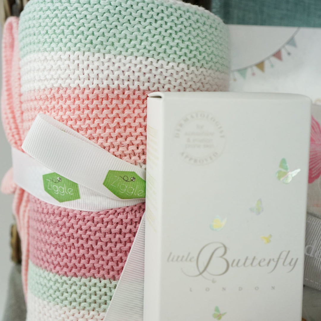 baby girl  hamper basket, pink pig baby comforter with chintz headband, pink pig soft toy with chintz headband, baby journal, organic baby toiletries, pink baby  bookies with a large bow,, Baby outfit -sleepsuit with lace chest area and matching hat in pink, soft luxury baby muslin swaddle with butterfly pattern, baby blanket in pink, white and green stripe