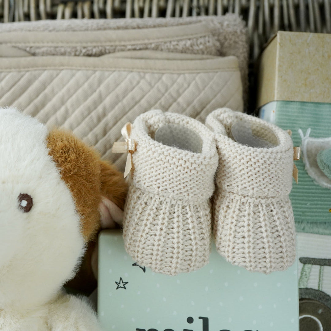 cow themed baby hamper with cow soft toy, comforter and rattle, farmyard soft blocks , baby milestone cards soft biscuit coloured hooded bath towel and knitted booties