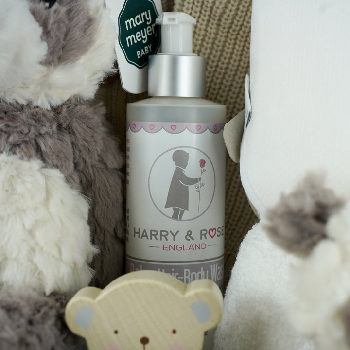 neutral baby hamper with grey and white panda soft teddy and matching baby comforter, cute white baby booties with ears and face, baby wooden push along toy,  baby toiletries, soft hooded towel , mum candle gift