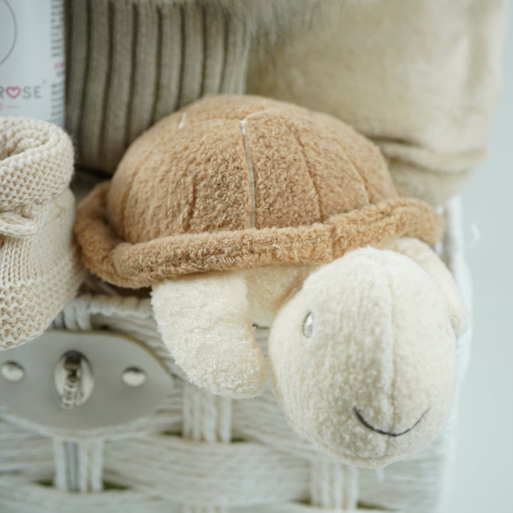 neutral baby hamper with baby dressing own, booties , baby journal, fluffy double pom pom hat, activity cube in neutral green, brown and cream with turtle, star fish and seahorse , soft turtle rattle toy