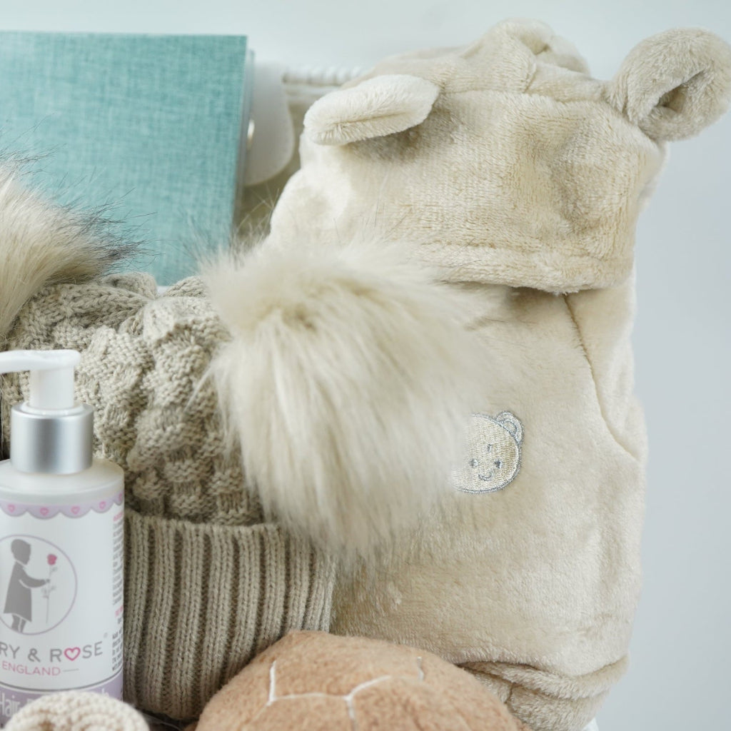 neutral baby hamper with baby dressing own, booties , baby journal, fluffy double pom pom hat, activity cube in neutral green, brown and cream with turtle, star fish and seahorse , soft turtle rattle toy