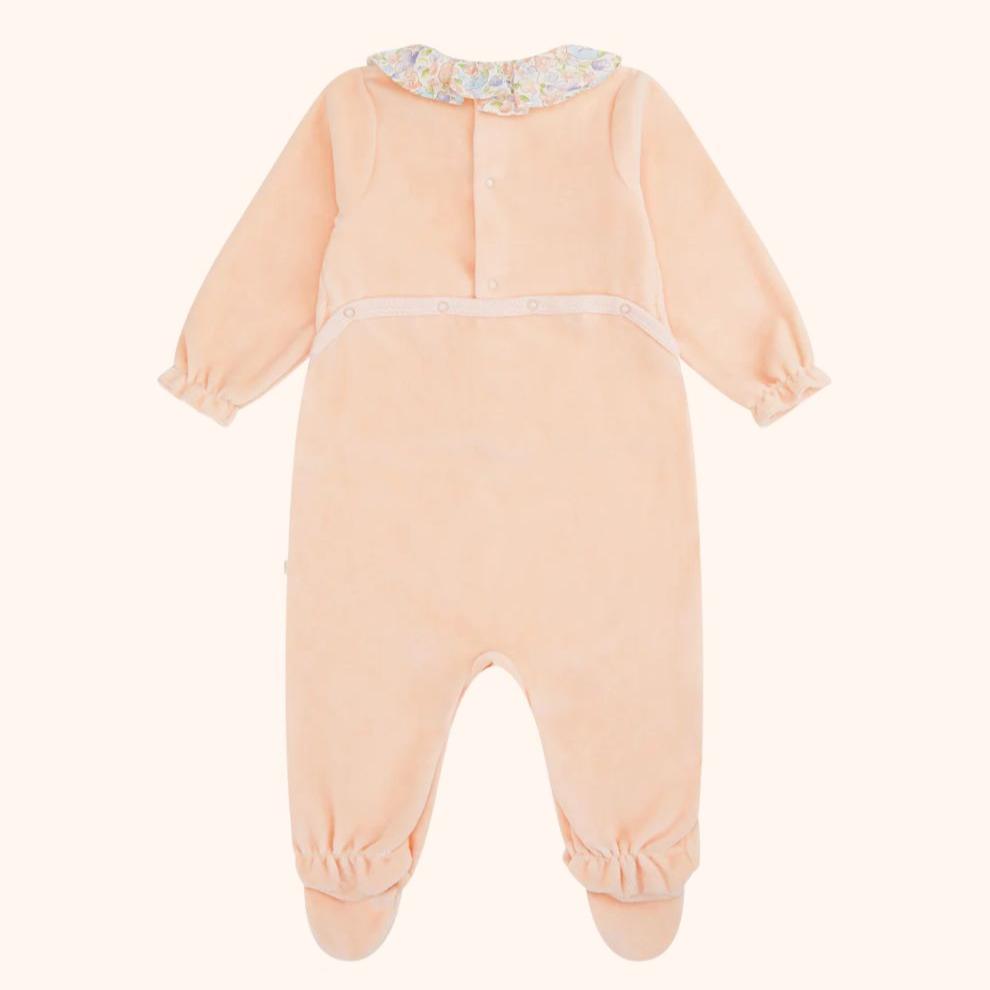 Olympia Velour Sleepsuit in pink features a floral ruffle collar.  Designed with comfort and quality the Olympia sleepsuit is a newborn must-have.
-Model wears 6M 
-Fits true to size with slight stretch 
-Ruffle collar & frill cuff design
-Snap fastenings at the back and along the inseam
-Footed design
