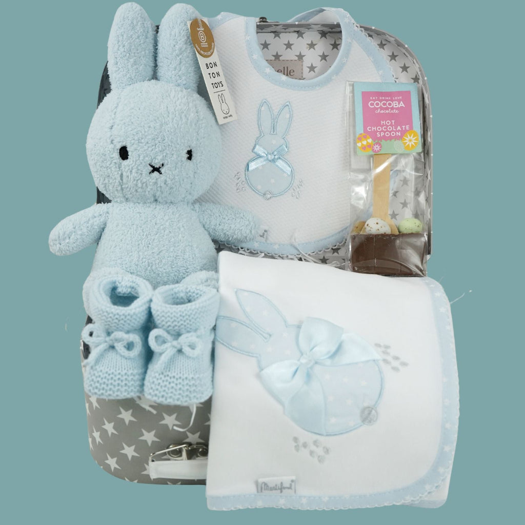 baby case with Blue miffy bunny, white and pale blue baby bib with applique bunny with a ribbon, white wrap with blue applique bunny with ribbon bow, blue knit booties