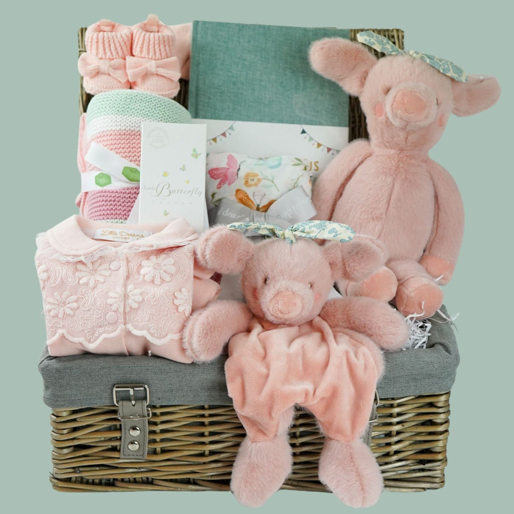 baby girl  hamper basket, pink pig baby comforter with chintz headband, pink pig soft toy with chintz headband, baby journal, organic baby toiletries, pink baby  bookies with a large bow,, Baby outfit -sleepsuit with lace chest area and matching hat in pink, soft luxury baby muslin swaddle with butterfly pattern, baby blanket in pink, white and green stripe