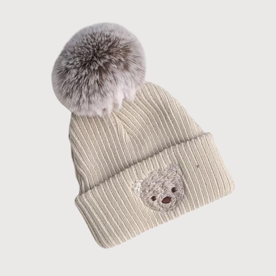 biscuit coloured baby pompom hat with embroidered teddy face
