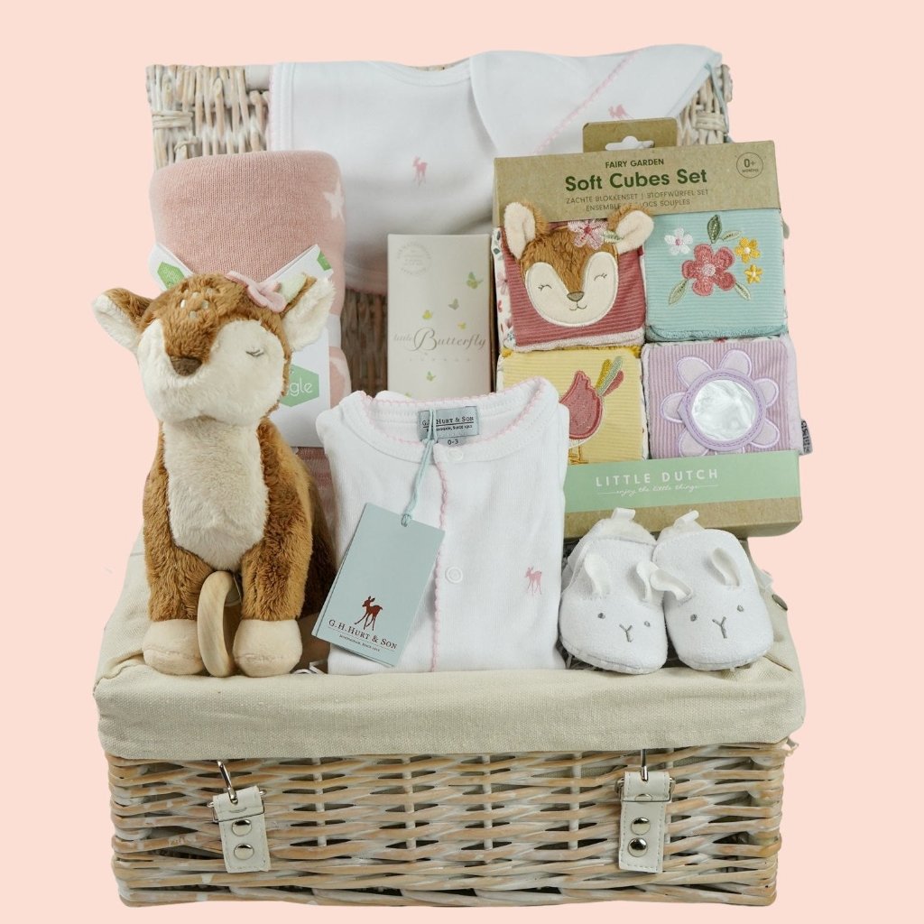 luxury baby hamper with sof cuddly deer with music, luxury white clothing set with pink deer and pink picot edging on sleepsuit, hat and baby bib, soft pink blanket with pale pink stars, white baby slippers with ears, set of four soft blocks with fawn and flowers