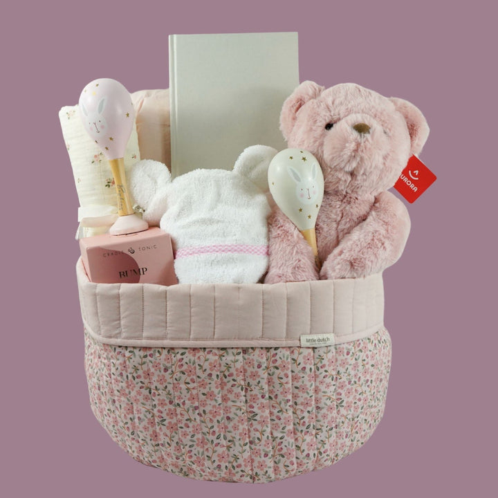 pink fairy floral quilted storage basket, reversible, white with pink flowers swaddle, white baby dressing gown with cute ears and pink and white gingham trim, bassinette quilt in pink, mama notes pregnancy diary, bump luxury mum candle, pink soft teddy, pink and grey maracas
