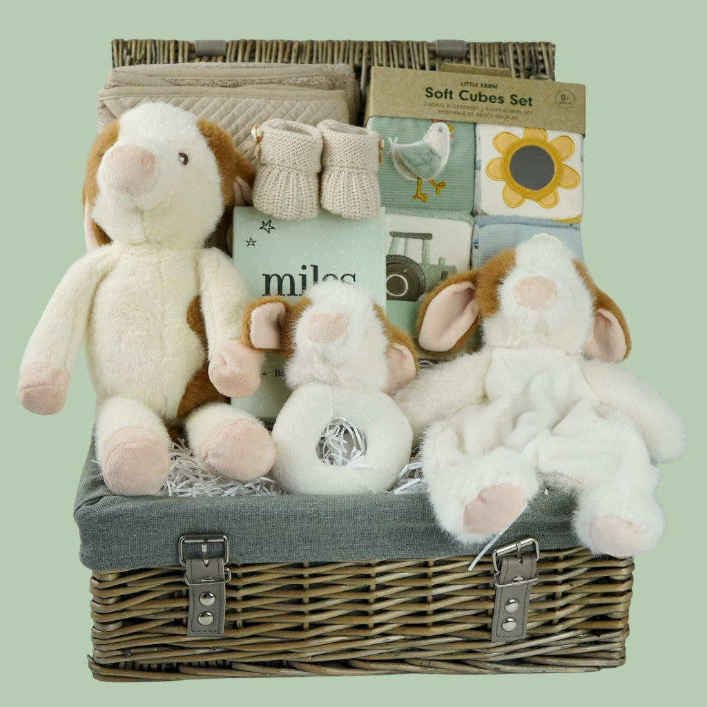 cow themed baby hamper with cow soft toy, comforter and rattle, farmyard soft blocks , baby milestone cards soft biscuit coloured hooded bath towel and knitted booties