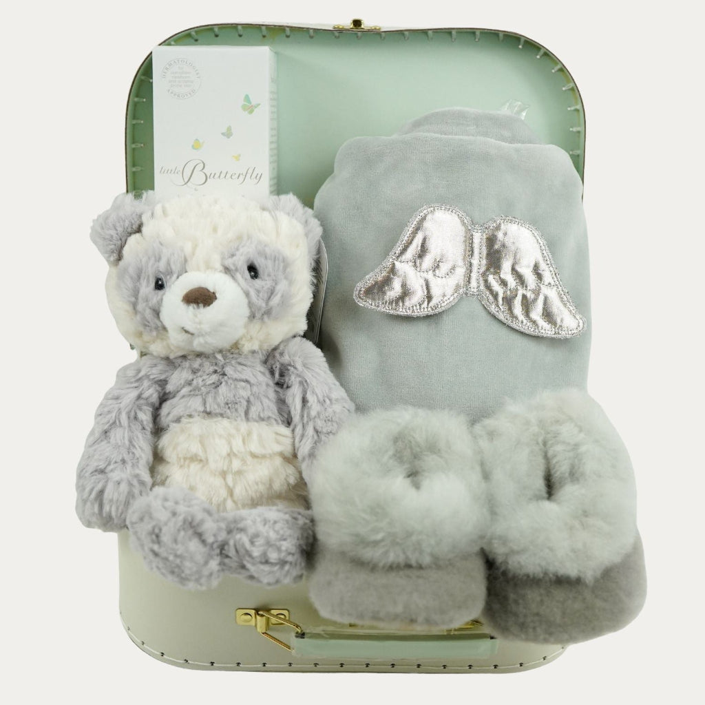 luxury neutral baby hamper in luxury baby keepsake suitcase in pale green with velour angel wings sleepsuit, organic baby toiletries, soft grey alpaca baby slippers and grey and white soft panda toy