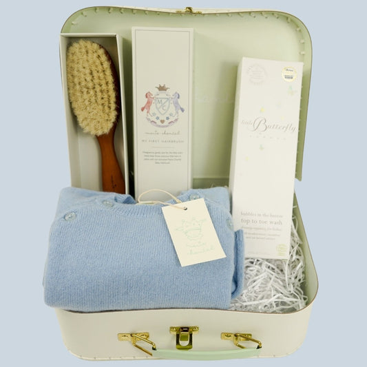 pale green Marie Chantal  case with natural hairbrush, cashmere romper in blue, natural baby toiletries 