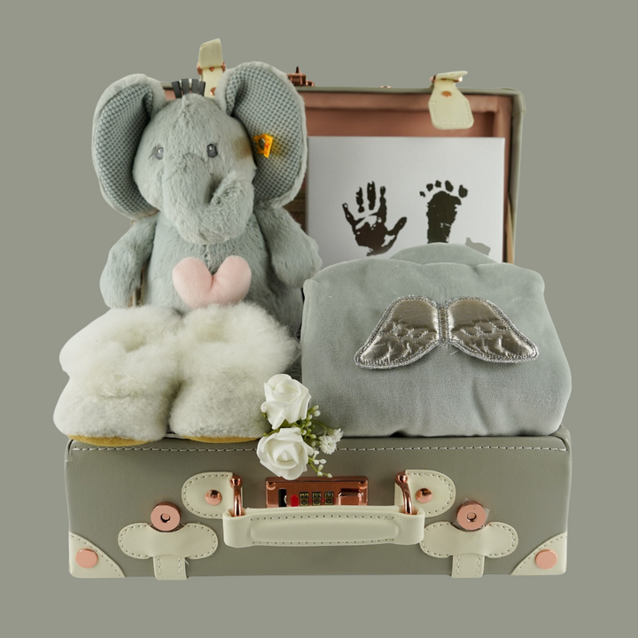 Grey baby suitcase with Steiff grey musical elephant, white alpaca wool baby slippers , grey with silver angel wings baby velour sleepsuit, baby handprint set