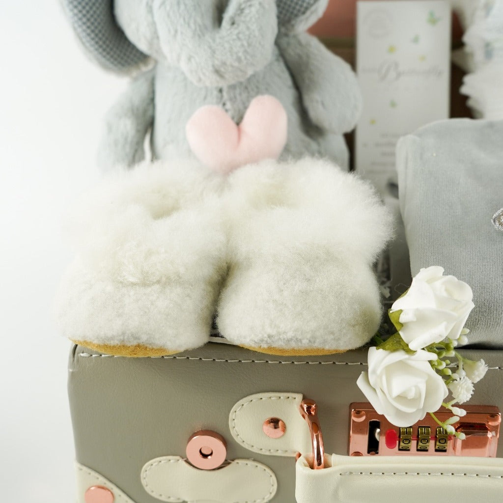 Grey baby suitcase with Steiff grey musical elephant, white alpaca wool baby slippers , grey with silver angel wings baby velour sleepsuit, baby handprint set