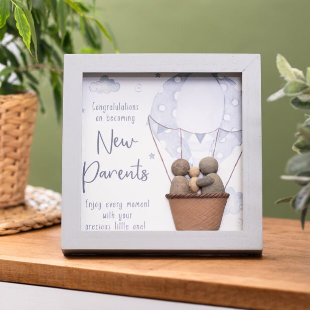 silver frame with picture of hot airballon with mum dad and baby made from pebbles