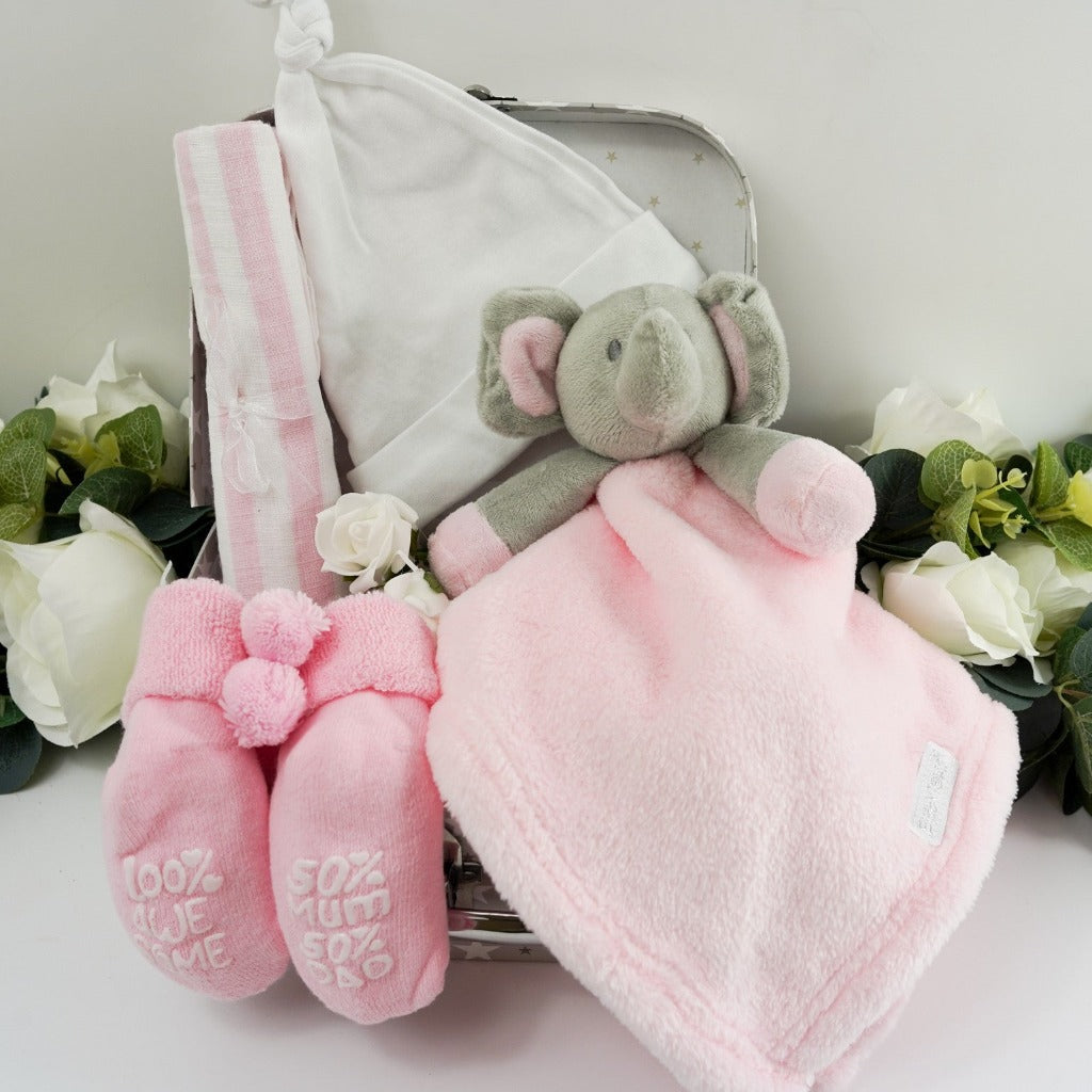 Small gift case with baby pink socks with cute writing on the sole, pink muslin, white baby knot hat, pink elephant baby comforter
