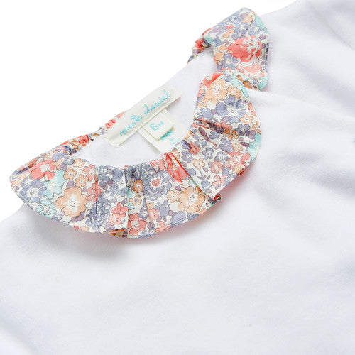 White velour baby sleepsuit with liberty print ruffle collar and libertiy print wings and trims around the cuffs, the sleepsuit is a soft velour