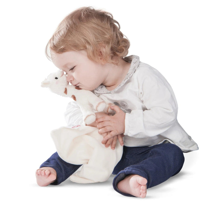 Plush giraffe toy comforter in a gift box with 'Sophie la girafe' branding.