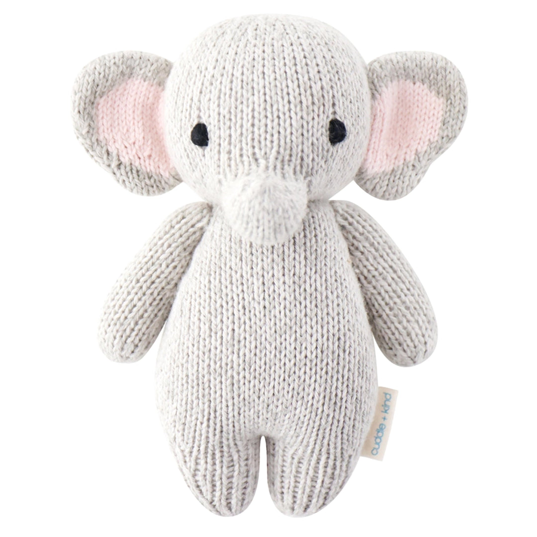 A knitted elephant plush toy in light gray with soft pink inner ears and small black bead eyes, photographed on a clean white background. A small fabric tag is visible near the lower right side.