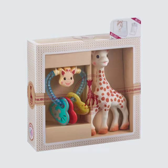 Toy set with a giraffe and colorful baby teether in a box on a light gray background