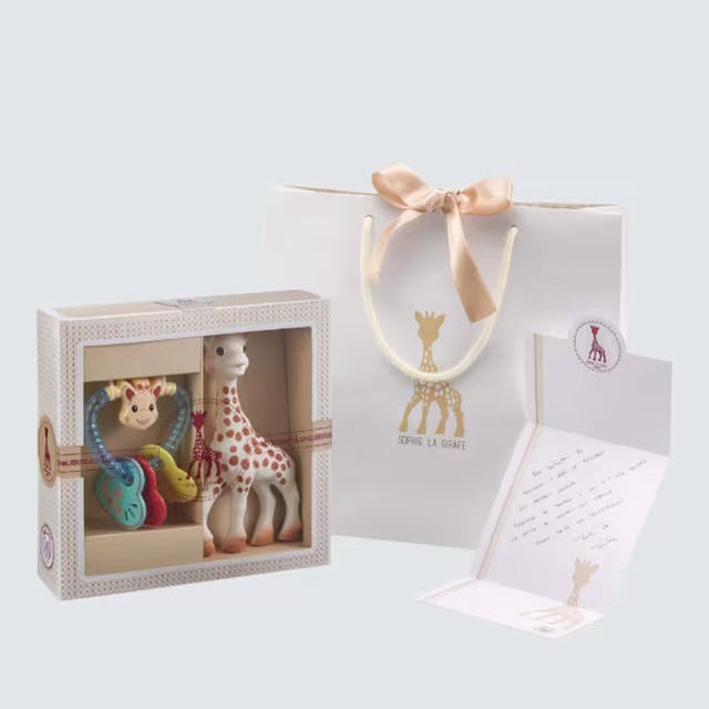 Giraffe toy with packaging and a teether rattle, gift bag and card