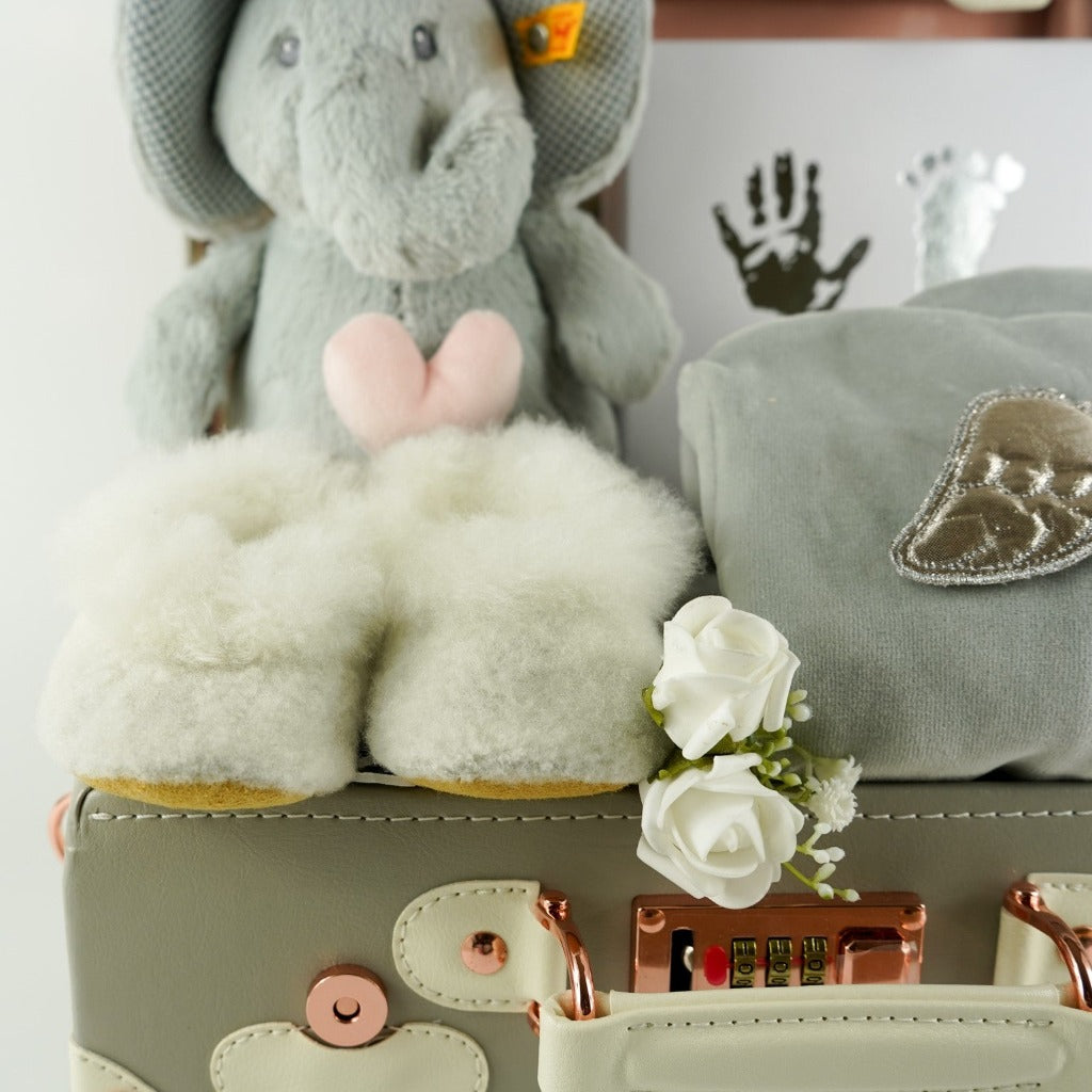 Grey baby suitcase with Steiff grey musical elephant, white alpaca wool baby slippers , grey with silver angel wings baby velour sleepsuit, baby handprint set 