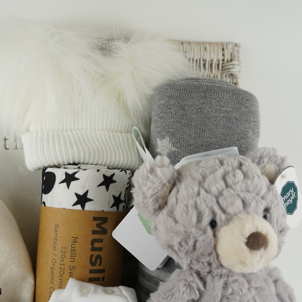 Pregnancy hamper basket with grey teddy, grey baby blanket with stars , black and white sensory baby swaddle, white baby hat with 2 Pom poms . White pregnancy journal. Pregnancy milestone discs, white baby clothing set includes jacket, bodysuit and leggings