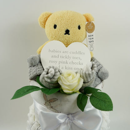 baby nappy cake, yellow boris bear, baby striped grey socks, baby knit bootees in grey with pom poms, baby dimple blanket in white with sherpa backing and teddy and rabbit applique , baby plaque