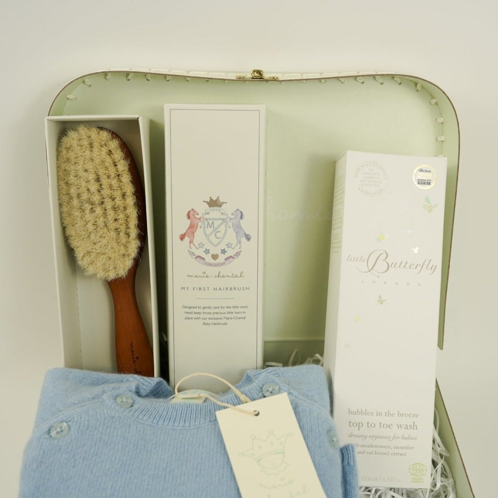 pale green Marie Chantal case with natural hairbrush, cashmere romper in blue, natural baby toiletries