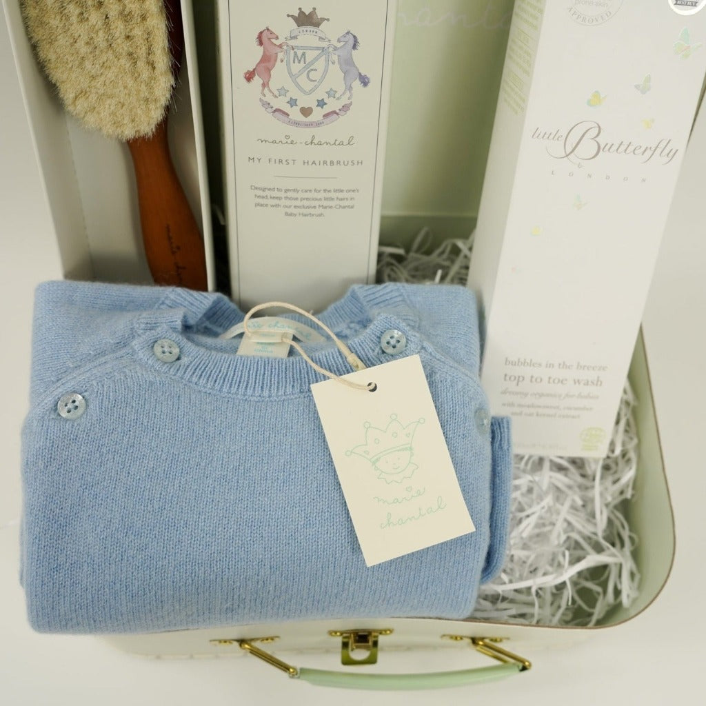 pale green Marie Chantal case with natural hairbrush, cashmere romper in blue, natural baby toiletries