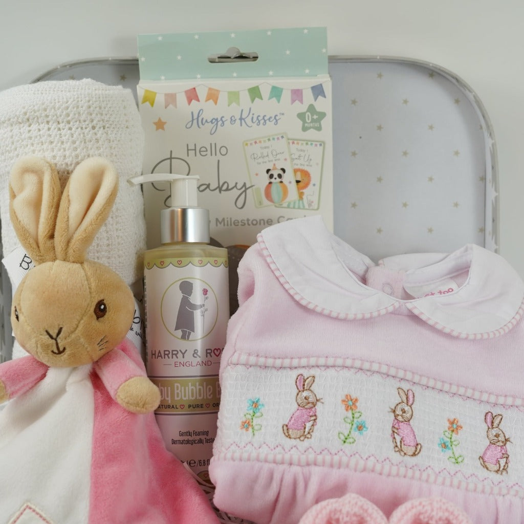 Baby girl hamper with flopsy bunny comforter in pink and white, baby cellular blanket, baby milestone cards , cute pink velour baby sleepsuit with smocked front with flopsy bunny, pink knit booties , baby organic wash