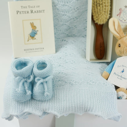 baby boy hamper, blue shawl by G H Hurts, blue knit booties , peter rabbit book, baby natural hairbrush, peter rabbit soft toy rattle
