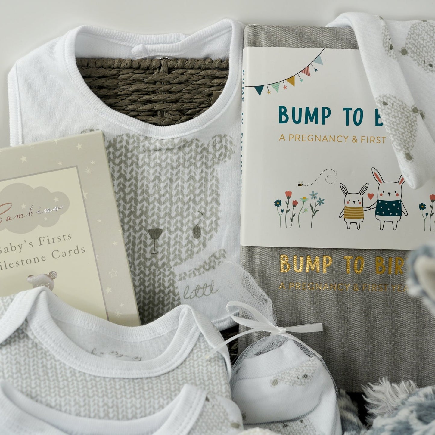 neutral baby hamper, baby clothing set in white with grey teddy faces, baby milestone cards, baby booties, bump to baby journal