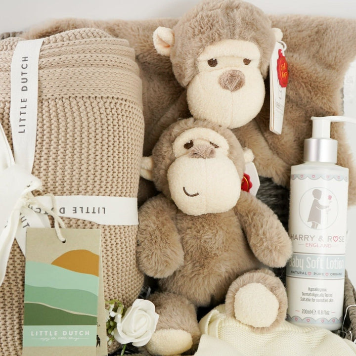 baby hamper with organi clothing set in cream with a black monkey face, soft organic blanket in beige, soft eco friendly monkey plush and matching monkey comforter, soft baby lotion organic