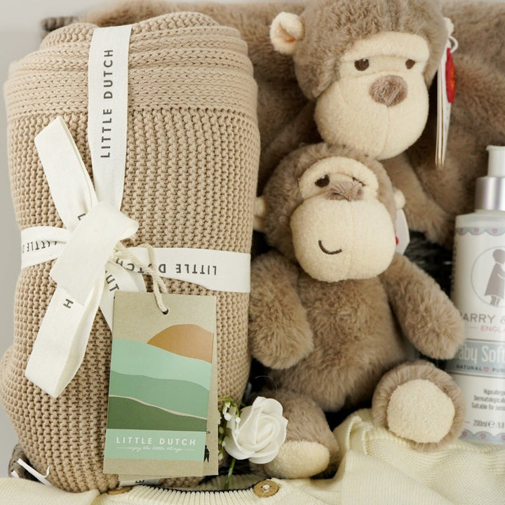 baby hamper with organi clothing set in cream with a black monkey face, soft organic blanket in beige, soft eco friendly monkey plush and matching monkey comforter, soft baby lotion organic