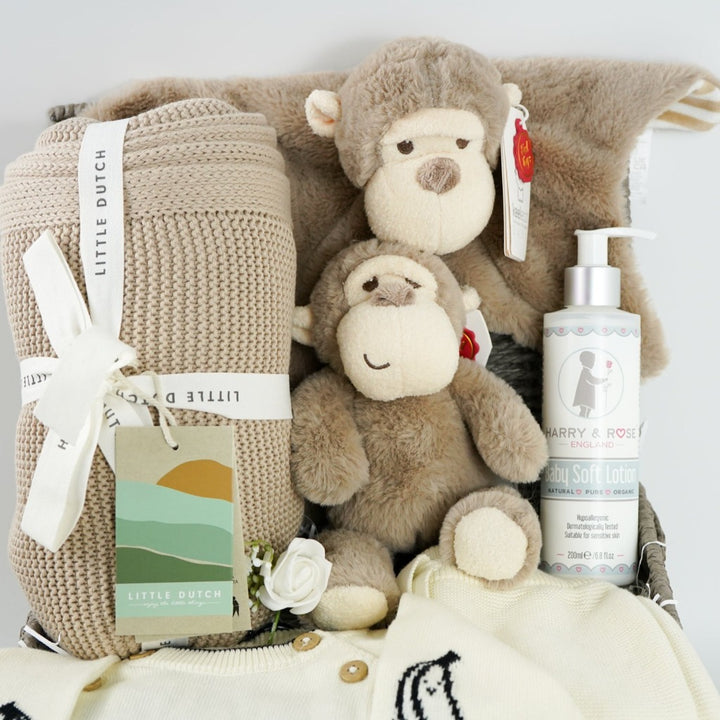 baby hamper with organi clothing set in cream with a black monkey face, soft organic blanket in beige, soft eco friendly monkey plush and matching monkey comforter, soft baby lotion organic