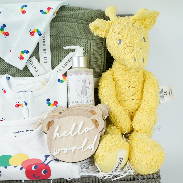 organic baby hamper, sage green organic baby blanket, white baby organic clothing nset with rainbow coloured catterpillars includes baby sleepsuit, baby hat with ears and bodysuit, organic baby wash, wooden baby milestone discs, yellow organic soft giraffe